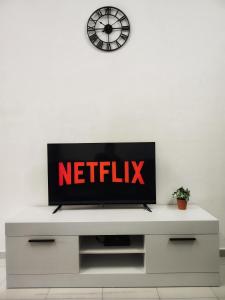 telewizor z płaskim ekranem siedzący na białej szafce w obiekcie Homestay Temerloh Near Hospital Wi-Fi Netflix w mieście Temerloh