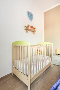 a baby crib in a room with white walls at Family apartment in Massa Lombarda