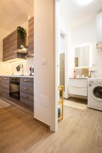 a kitchen with white cabinets and a washer and dryer at Family apartment in Massa Lombarda