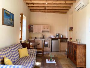 a living room with a couch and a kitchen at Eveleos Country House in Tochni