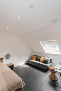 Habitación blanca con sofá y ventana en Vakantiehuis Vélolit en Oudenaarde