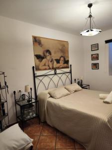 1 dormitorio con 1 cama y una pintura en la pared en Casa Dante, en Tías