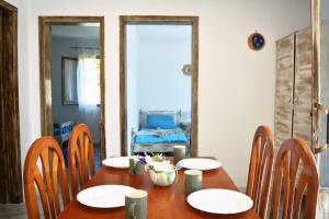 a wooden table with chairs and a table with flowers on it at Afroditi Ground floor apartment in Achílleion
