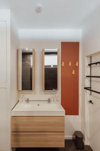 a bathroom with a sink and two windows at Vakantiehuis Vélolit in Oudenaarde