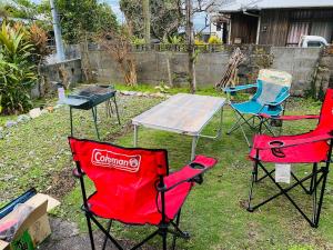 três cadeiras e uma mesa num quintal com uma mesa em Yamato inn - Vacation STAY 86368v em Amami