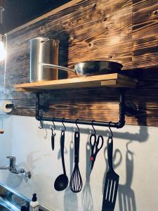 a group of utensils hanging on a shelf in a kitchen at Yamato inn - Vacation STAY 86368v in Amami