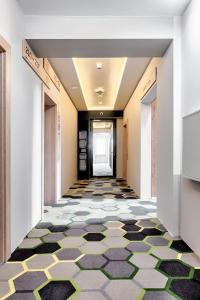 um corredor com piso em azulejo num edifício em Citi Hotel's Łódź em Lódź