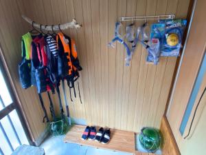a room with a wooden wall with a bunch of clothes at Yamato inn - Vacation STAY 86368v in Amami