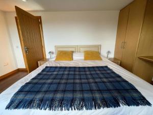 um quarto com uma cama com um cobertor azul em Berryhill East Steading - Sleeps 6 - Peterhead - Dog Friendly - Rural Location -Smart TV - Golf Driving Range - EV Point em Peterhead