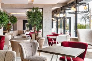 um restaurante com mesas, cadeiras e janelas em Citi Hotel's Łódź em Lódź