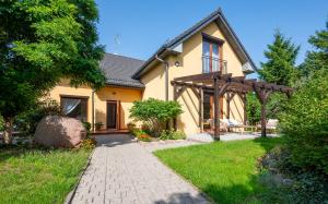 a house with a pathway in front of it at Akacjowa Zatoka - Pokoje i Apartamenty in Mielenko