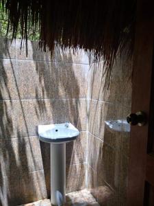 a bathroom with a sink and a stone wall at Playa Paraiso Nagtabon Beach in Bacungan