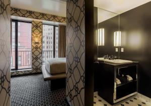 een badkamer met een wastafel en een spiegel bij 45 Times Square Hotel in New York
