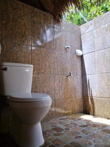 a bathroom with a toilet and a tiled wall at Playa Paraiso Nagtabon Beach in Bacungan