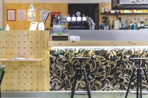 a bar with a patterned counter and stools at The Originals City Hotel Artyster Clermont Ferrand in Clermont-Ferrand
