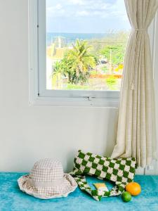 a window with two pillows on a blue counter with a view at Tuna Hotel Phú Yên in Liên Trì (3)
