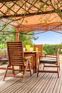 Duas cadeiras e uma mesa num deque com um guarda-sol em Villa Demiana by Ezoria Villas em Coral Bay