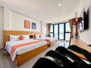 ein Hotelzimmer mit zwei Betten und einem Flachbildfernseher in der Unterkunft Tuna Hotel Phú Yên in Liên Trì (3)