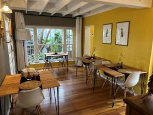 比勒陀利亚Battiss Guest House的一间有桌椅和窗户的餐厅