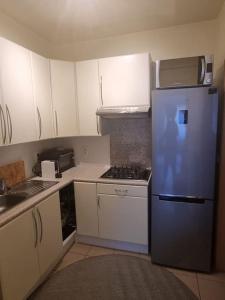 a kitchen with white cabinets and a blue refrigerator at Belle maison ! in Brussels