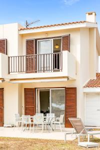 a group of chairs and tables in front of a house at Villa Demiana by Ezoria Villas in Coral Bay