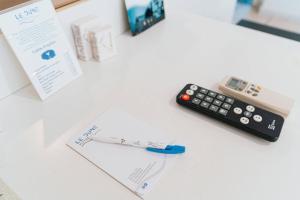 a remote control and a thermometer sitting on a desk at Hotel Le Dune in Sampieri