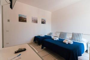 1 dormitorio con 2 camas y sábanas azules en Hotel Le Dune en Sampieri