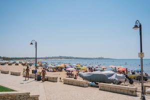 a beach with a lot of people and umbrellas at Hotel Le Dune in Sampieri