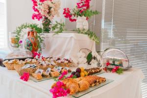 a table with pastries and other foods on it at Hotel Le Dune in Sampieri