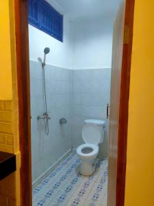 ein Bad mit einem weißen WC in einem Zimmer in der Unterkunft Candra Asri Bungalow in Ubud