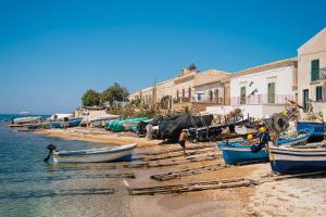 a group of boats on the shore of a beach at Hotel Le Dune in Sampieri