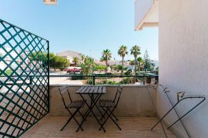 a balcony with a table and chairs and a view of a street at Hotel Le Dune in Sampieri