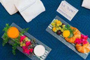 a table with two plates of fruit and a glass of milk at Hotel Le Dune in Sampieri