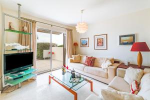 ein Wohnzimmer mit Sofa und Fernseher in der Unterkunft Villa Demiana by Ezoria Villas in Coral Bay