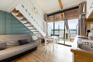 a living room with a couch and a staircase at Les Lofts du Grand Lac de Lozère in Langogne