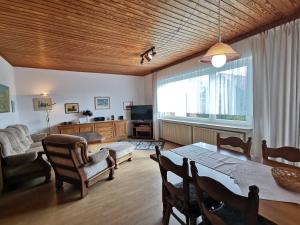 sala de estar con mesa, sillas y sofá en Sandstrand, en Wangerland
