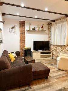 sala de estar con sofá y TV de pantalla plana en Casa en primera linea de playa, en Puzol