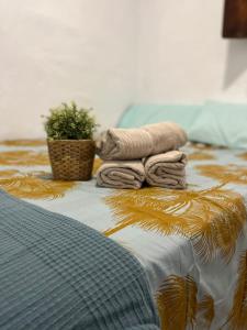 Una cama con toallas y una planta. en Casa en primera linea de playa, en Puzol