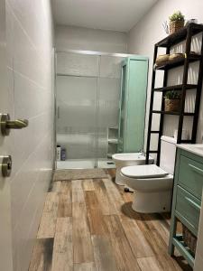 a bathroom with a toilet and a glass shower at Casa en primera linea de playa in Puzol +37 photos