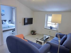 ein Wohnzimmer mit einem blauen Sofa und einem Bett in der Unterkunft Hafen Quartier in Sassnitz