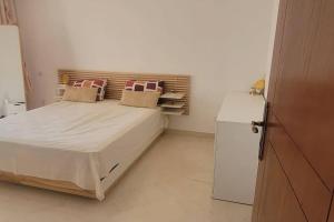 a small bedroom with a bed and a refrigerator at Appartement à Bizerte in Bizerte