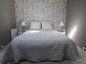 a bedroom with a large bed with a gray blanket at Parenthèse Bleue à Cabourg in Cabourg