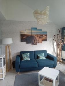 a living room with a blue couch and a brick wall at Parenthèse Bleue à Cabourg in Cabourg
