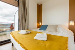 1 dormitorio con 1 cama grande y toallas. en Les Lofts du Grand Lac de Lozère, en Langogne