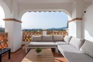 ein Wohnzimmer mit einem Sofa auf dem Balkon in der Unterkunft Golfer's dream apartment in Mijas Golf Ref 81 in Santa Fe de los Boliches