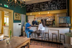 tres personas sentadas en un bar en un restaurante en Stayokay Hostel Domburg, en Oostkapelle