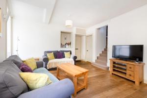 uma sala de estar com um sofá e uma televisão em ALTIDO Charming 2-bed house with Courtyard em Edinburgo