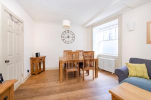 a living room with a table and chairs and a couch at ALTIDO Charming 2-bed house with Courtyard in Edinburgh
