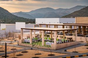 Damask Resort في Jabal Al Akhdar: تقديم عمارة فيها جبال في الخلف