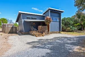 ein modernes Haus mit einer Garage und einer Auffahrt in der Unterkunft The Inlet Stanley in Stanley